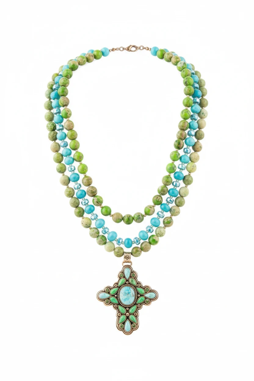 Necklace with green and blue beads on a white stand