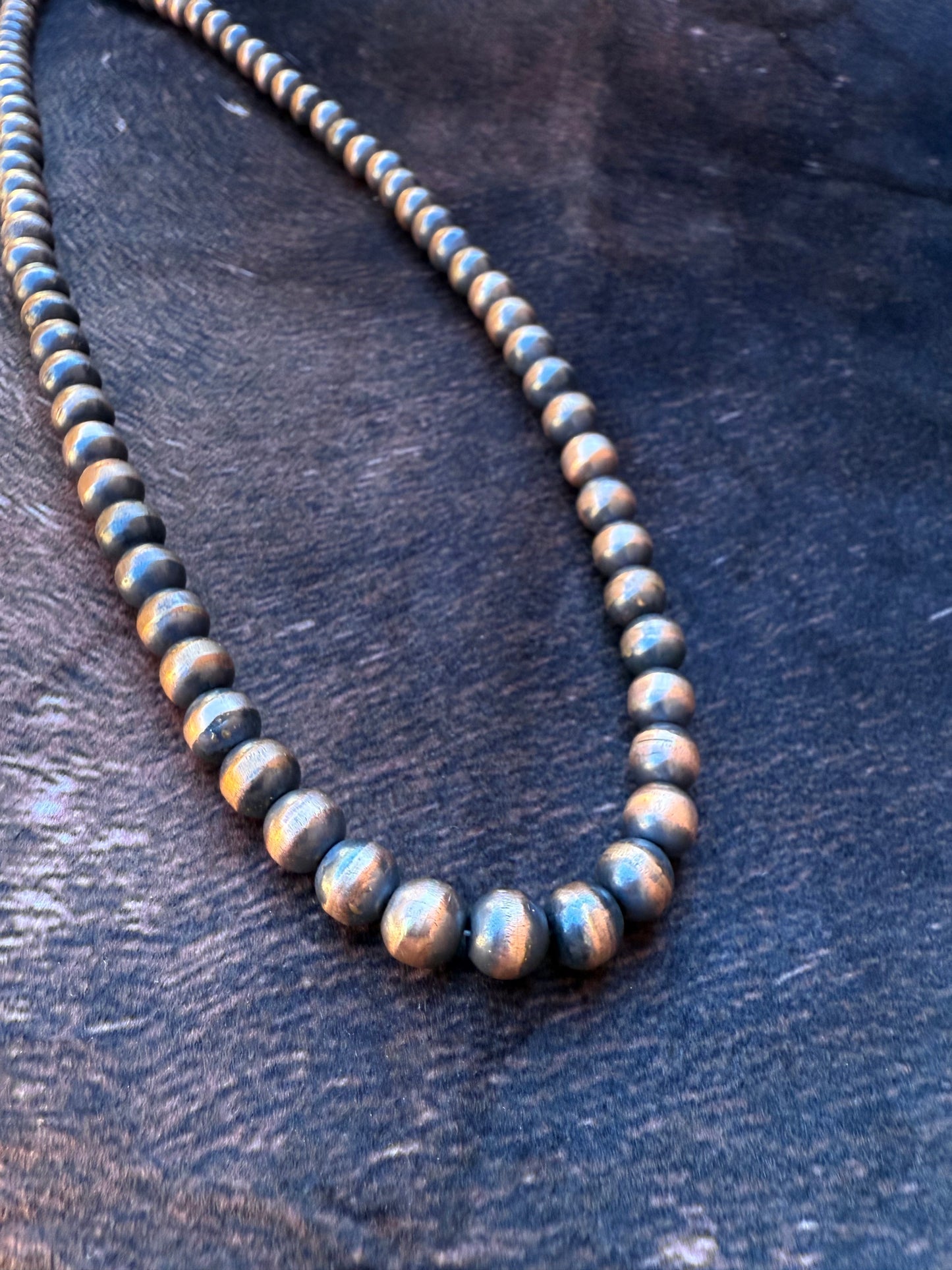 Necklace with round beads on a dark wooden surface