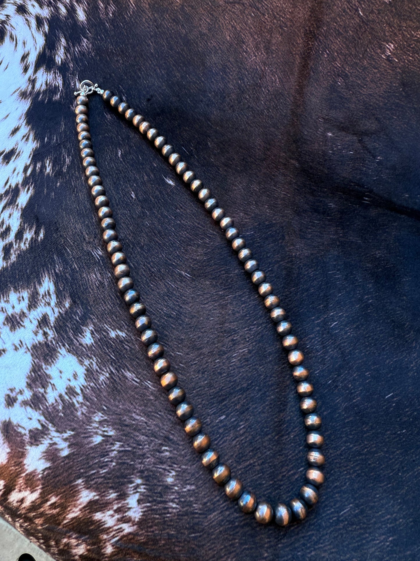 Necklace with beads on a cowhide surface