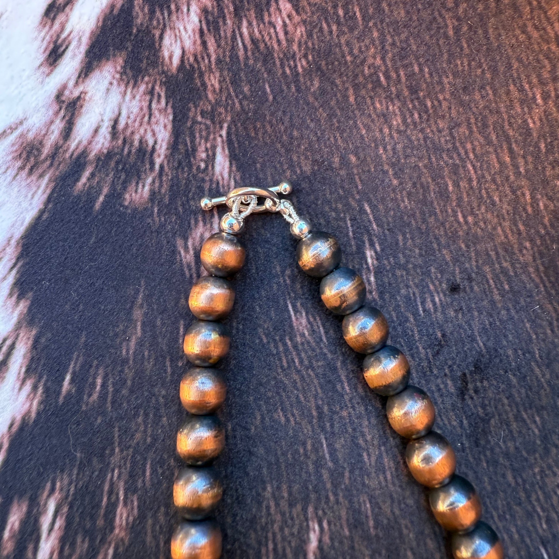Bracelet with brown and silver beads on a fur surface
