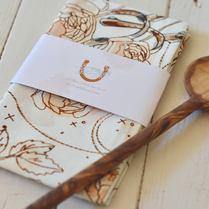Wooden spoon and patterned napkin on a wooden surface