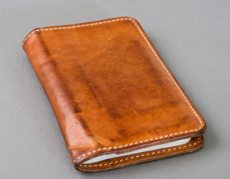 Brown leather wallet on a gray background