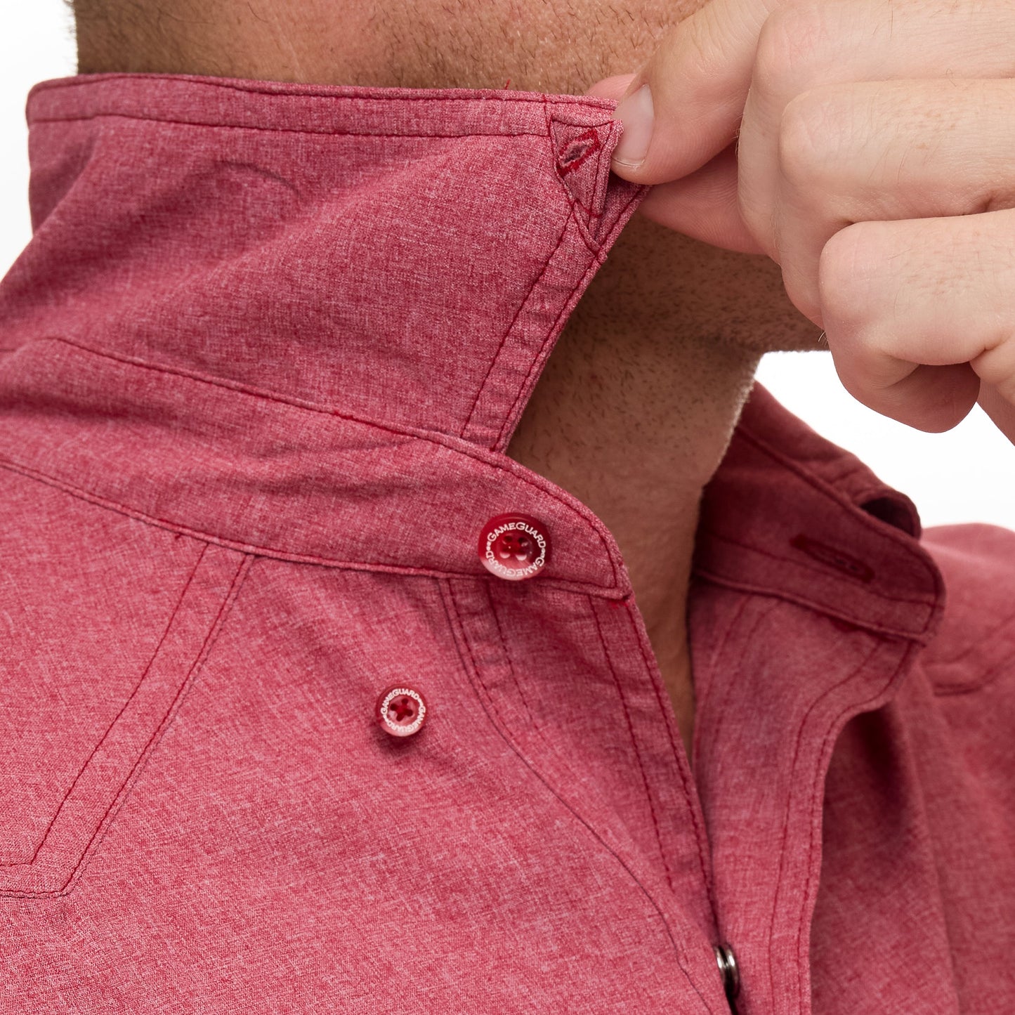 Close-up of a person adjusting the collar of a red shirt.