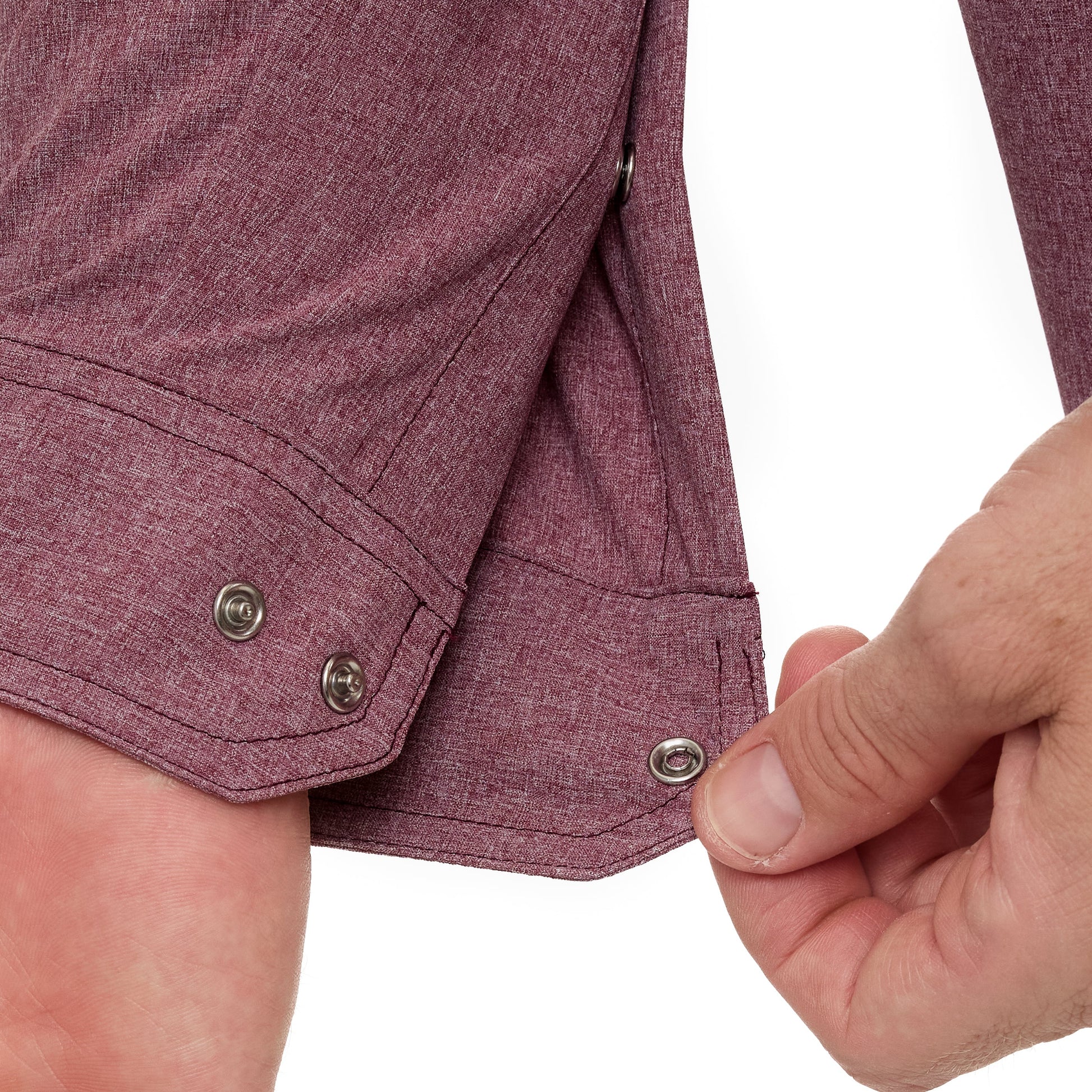 Close-up of a person buttoning a maroon shirt on a white background