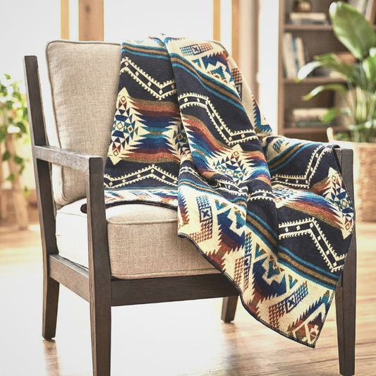 Colorful patterned blanket draped over a chair in a room with plants and furniture.