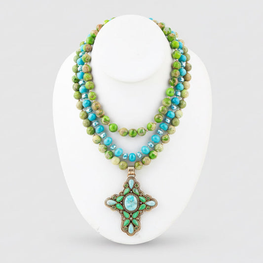 Necklace with green and blue beads on a white stand
