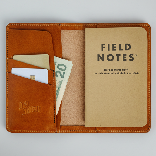 Brown leather wallet with a 'Field Notes' notebook and money