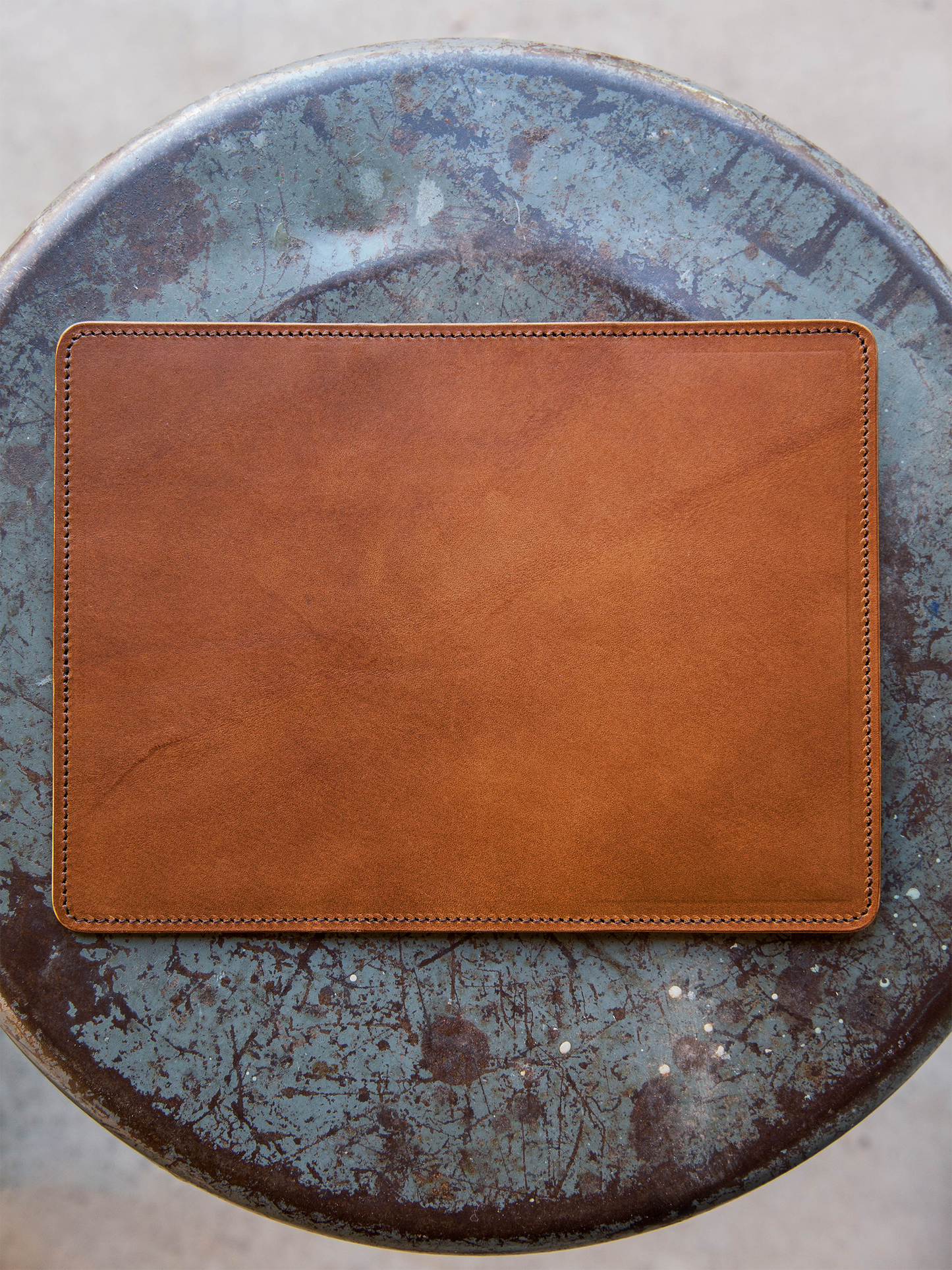 Brown leather wallet back on a textured blue surface