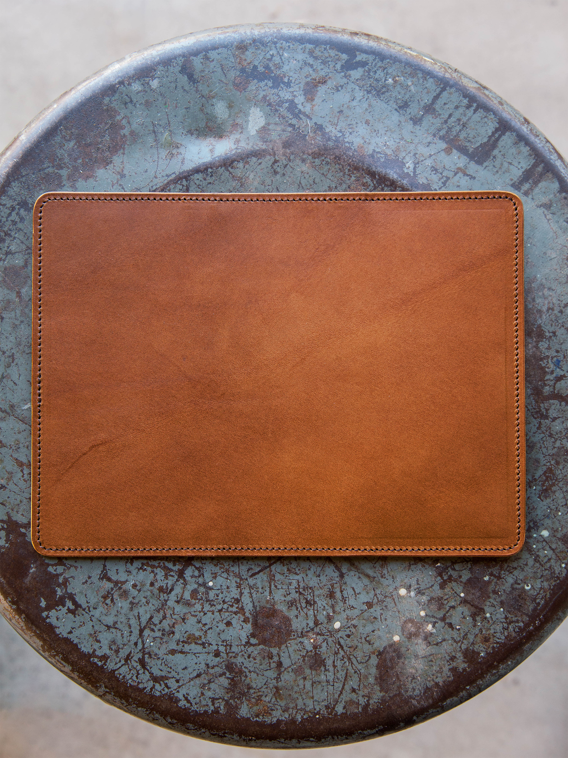Brown leather wallet back on a textured blue surface