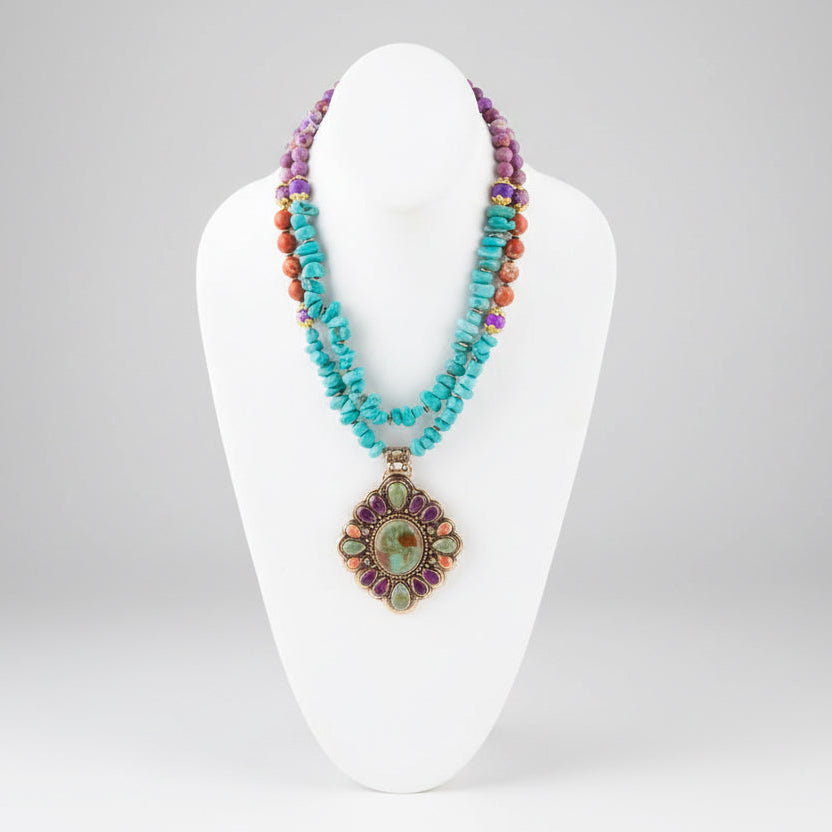 Colorful beaded necklace with a large pendant on a white stand